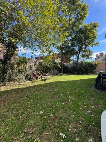 a view of a field with large trees