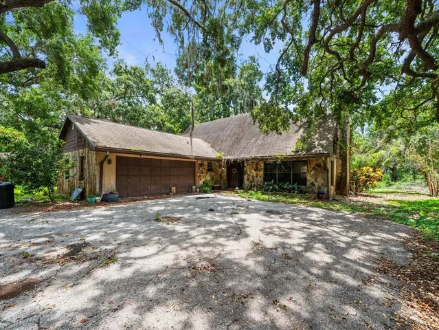 a front view of a house with yard and tree