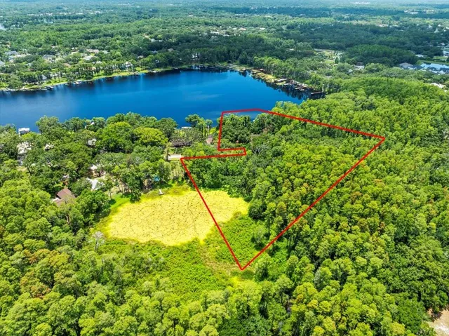an aerial view of residential houses with outdoor space and a lake view