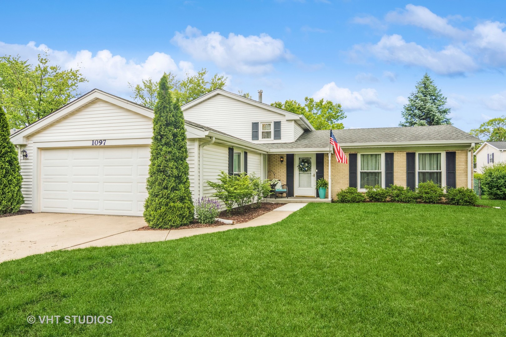 1097 Greenridge Road Buffalo Grove, IL 60089 - Photo 1 of 27 a front view of a house with a garden and plants