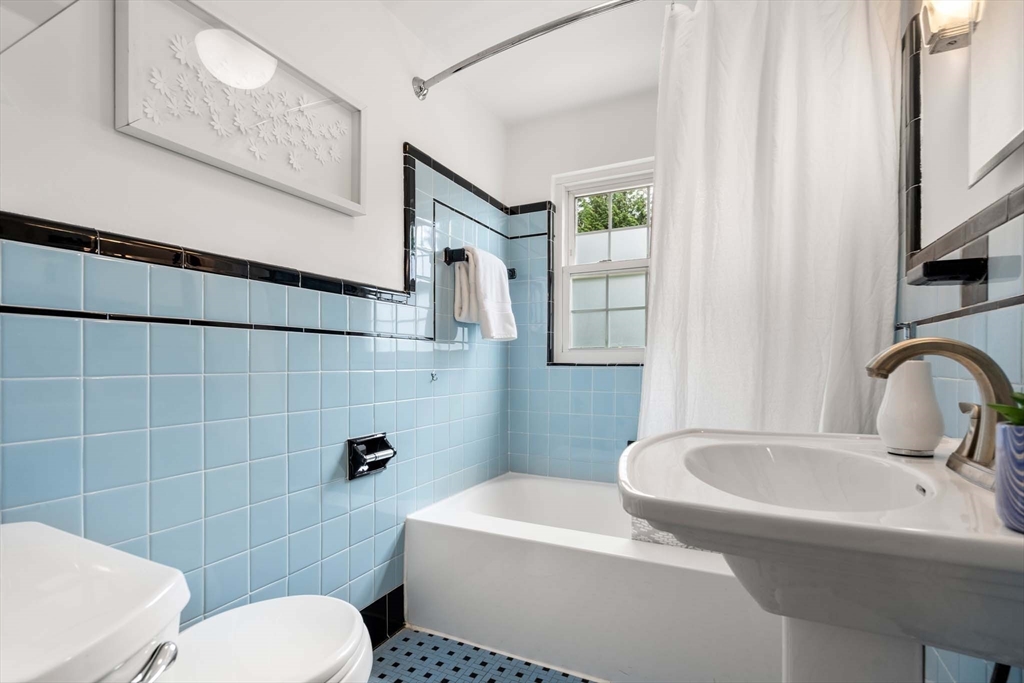 226 Grove Street Brookline, MA 02467 - Photo 12 of 23 a bathroom with a sink a toilet a mirror and shower