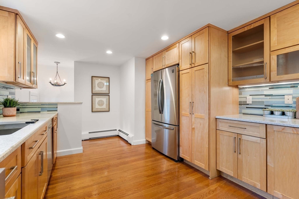 226 Grove Street Brookline, MA 02467 - Photo 7 of 23 a kitchen with white cabinets and stainless steel appliances