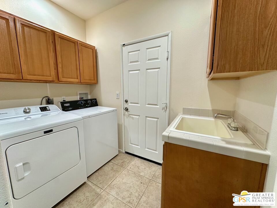 83530 Fenton Court Indio, CA 92203 - Photo 13 of 14 a utility room with cabinets washer and dryer