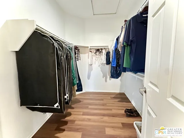 a view of walk in closet with clothes and shoes
