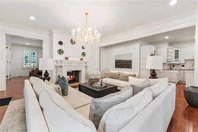 a living room with furniture a fireplace and a chandelier