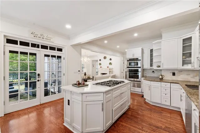 a kitchen with stainless steel appliances kitchen island granite countertop a stove a sink and a refrigerator