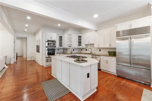 a kitchen with stainless steel appliances a stove a sink and a refrigerator