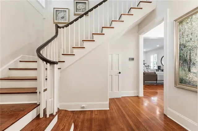 a view of a hallway with wooden floor and staircase
