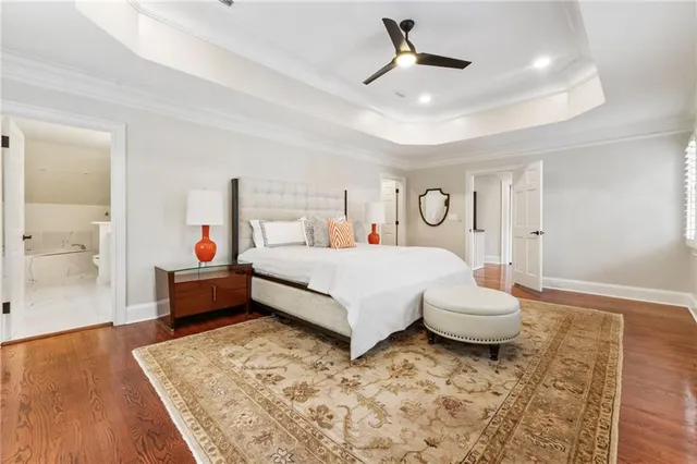 a spacious en suite bathroom with a double vanity sink large mirror and a bathtub