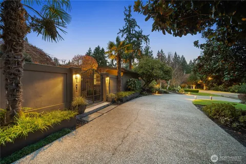 a view of a house with a yard and palm trees