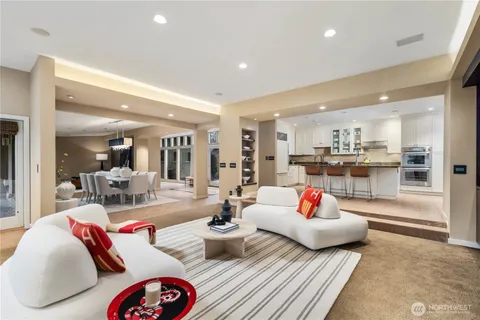 a kitchen with granite countertop a stove a sink a dining table and chairs