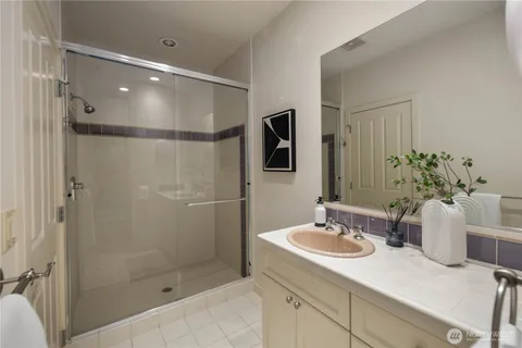 a view of patio with couches and table and chairs under an umbrella with a small yard