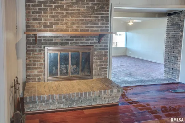 a view of a livingroom with wooden floor and a fireplace