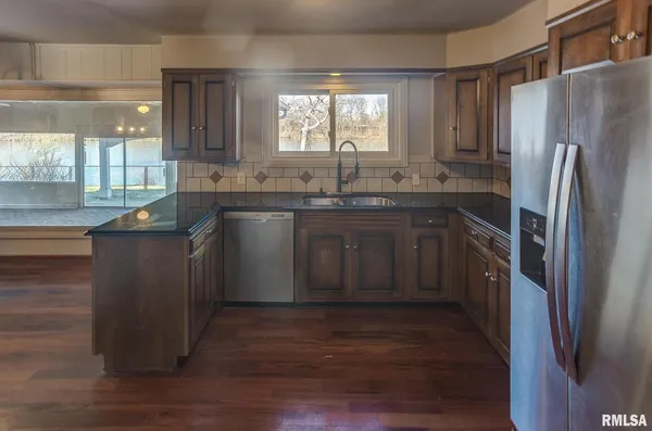 a kitchen with granite countertop a sink stove and refrigerator