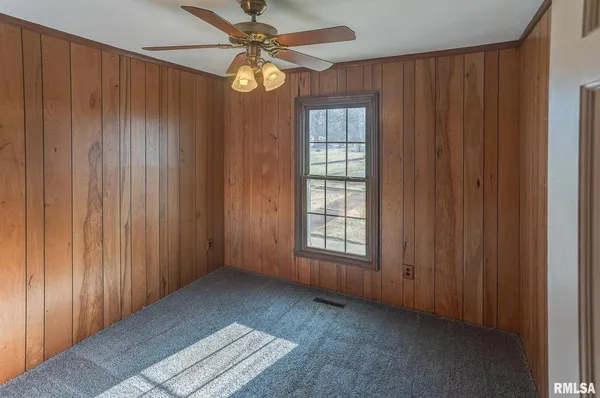 an empty room with windows closet and fan