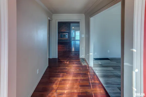 a view of a hallway with wooden floor and staircase