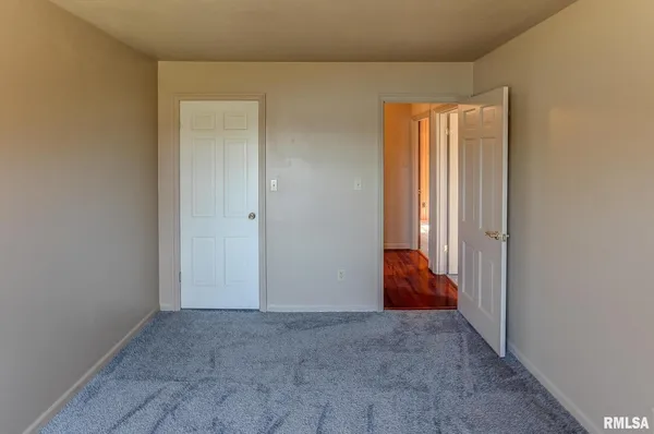 an empty room with windows and chandelier fan