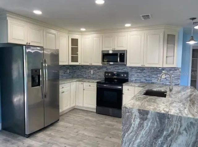 a kitchen with a refrigerator stove and microwave