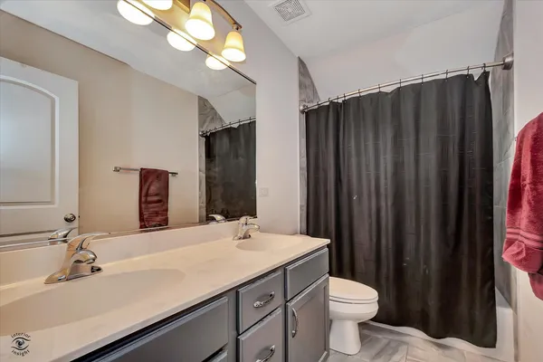 a bathroom with a sink vanity mirror and toilet