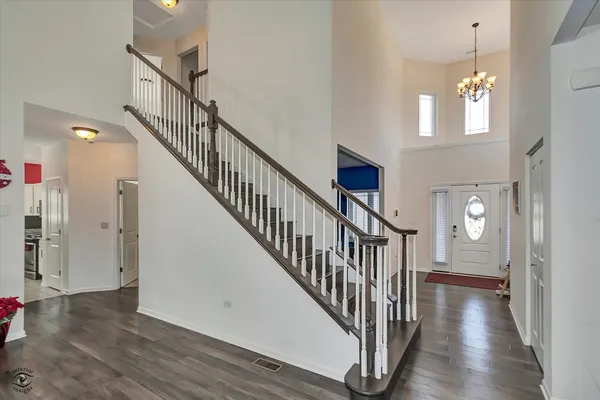 a view of a hallway with dining room and wooden floor