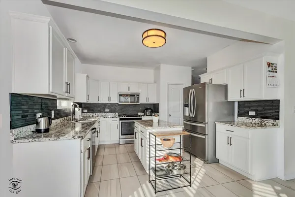 a kitchen with a refrigerator a stove top oven a sink and cabinets