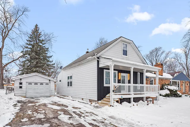 a front view of a house with a yard covered in snow