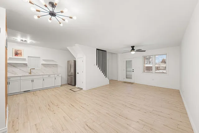 a view of empty room with wooden floor and ceiling fan