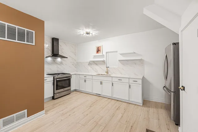 a kitchen with granite countertop a stove top oven a sink dishwasher and a refrigerator with wooden floor