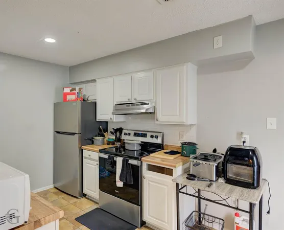 a kitchen with a refrigerator a stove top oven a sink and cabinets