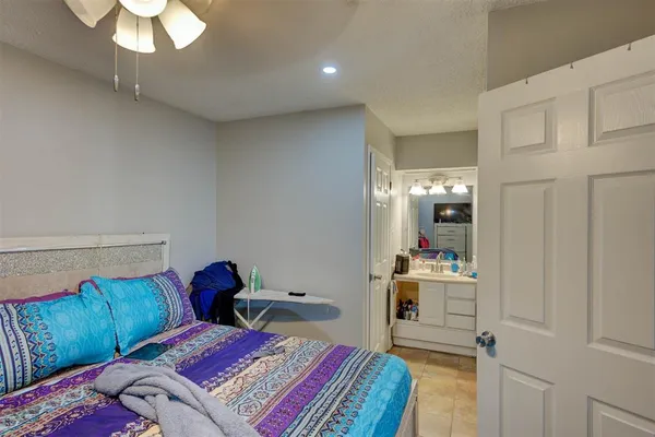 a bedroom with a bed and a mirror on dresser
