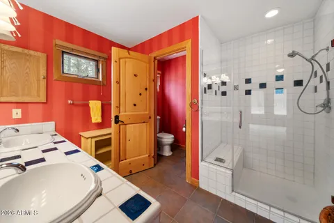 a bedroom with a bed a chandelier and a dresser