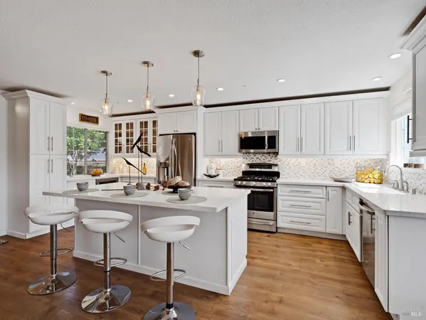 a kitchen with kitchen island white cabinets and stainless steel appliances