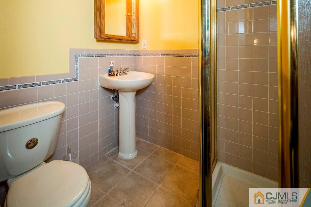 27 Old Post Road Edison, NJ 08817 - Photo 22 of 25 a bathroom with a sink a toilet and a mirror