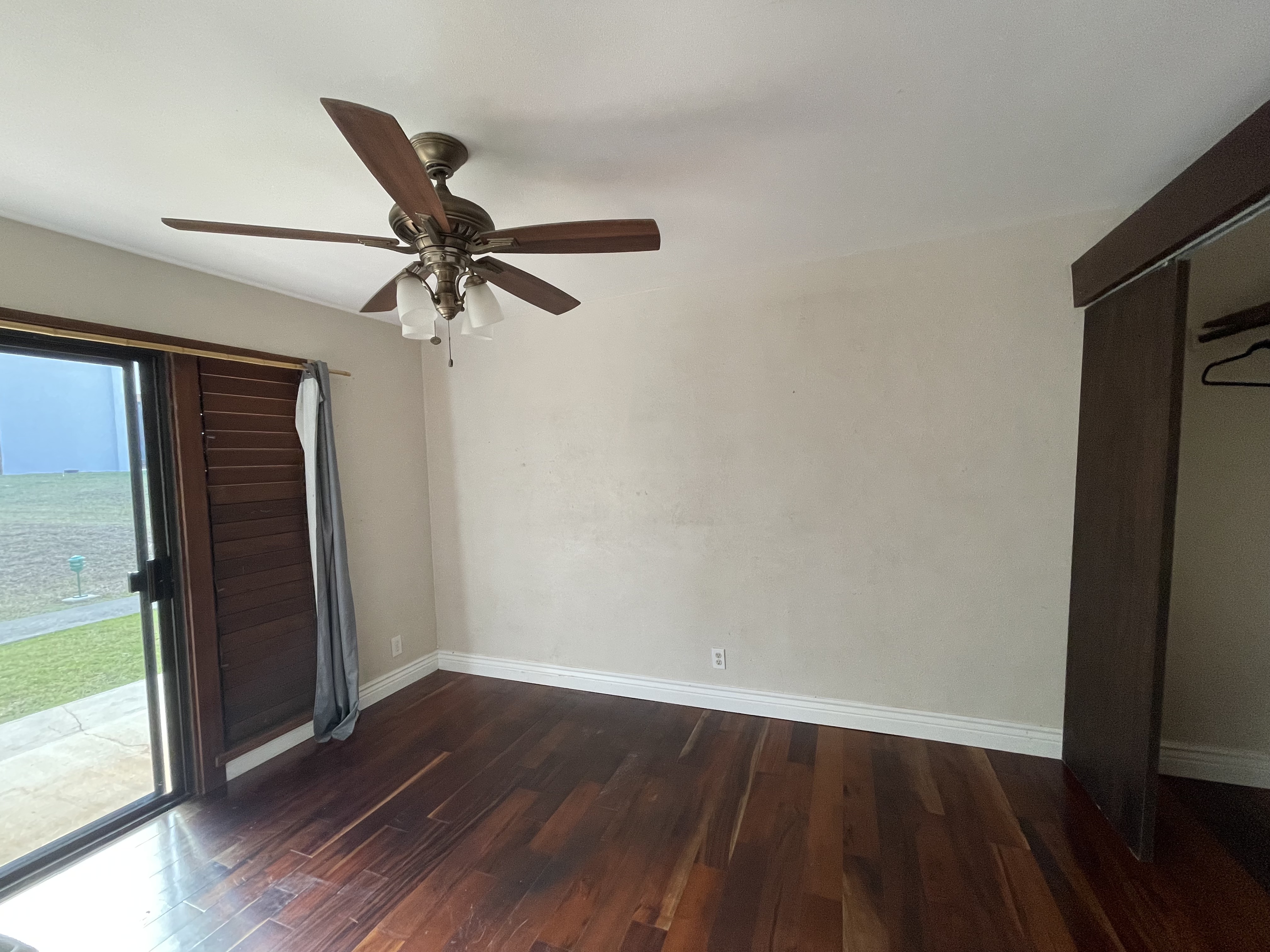 4701 Kawaihau Road, Unit L102 Kapaa, HI 96746 - Photo 7 of 10 an empty room with wooden floor fan and windows