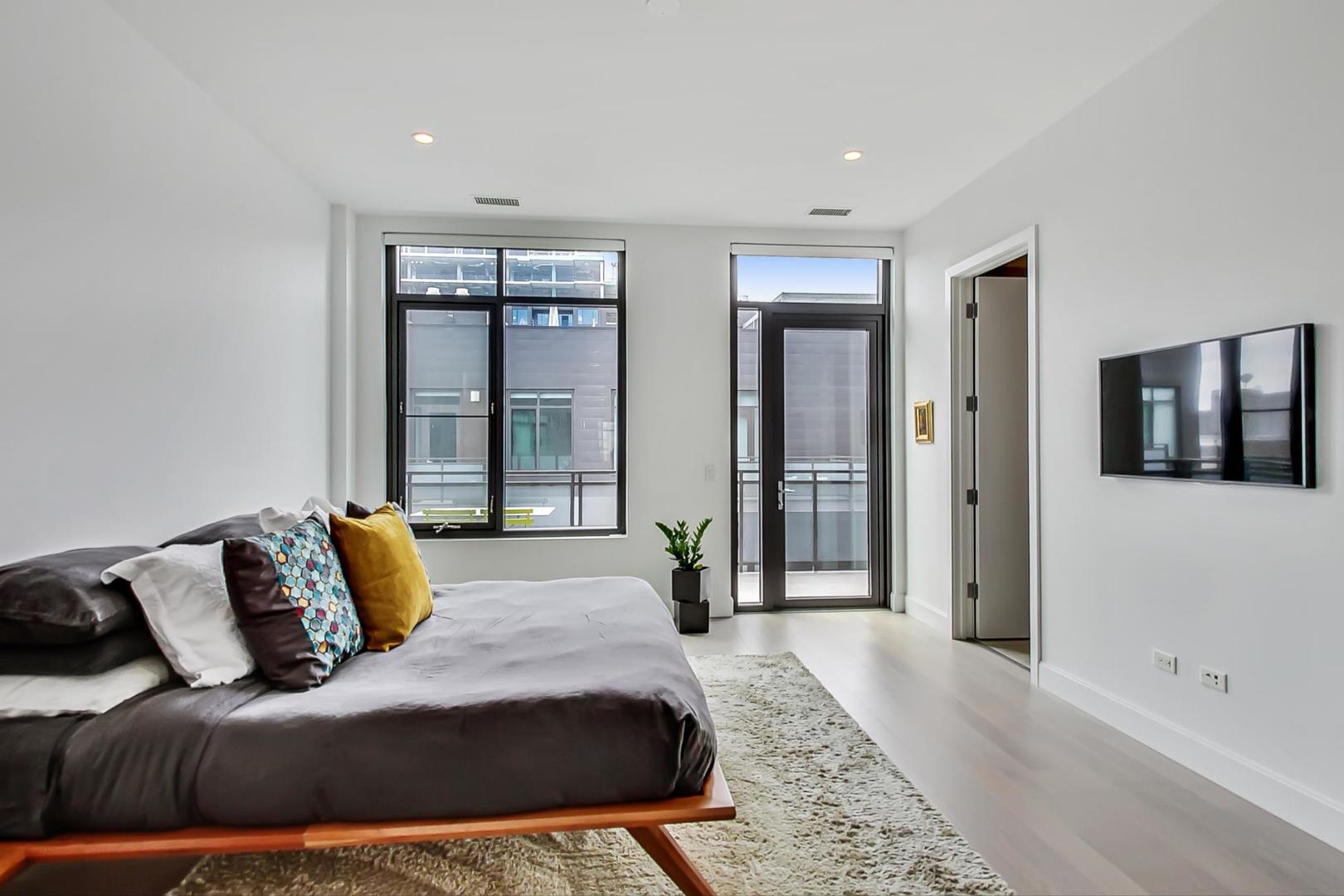 28 North Carpenter Street, Unit PHN Chicago, IL 60607 - Photo 5 of 14 a bedroom with a large bed and a couch