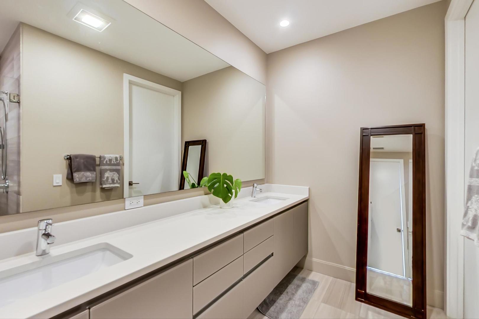 28 North Carpenter Street, Unit PHN Chicago, IL 60607 - Photo 6 of 14 a bathroom with a granite countertop sink and a mirror