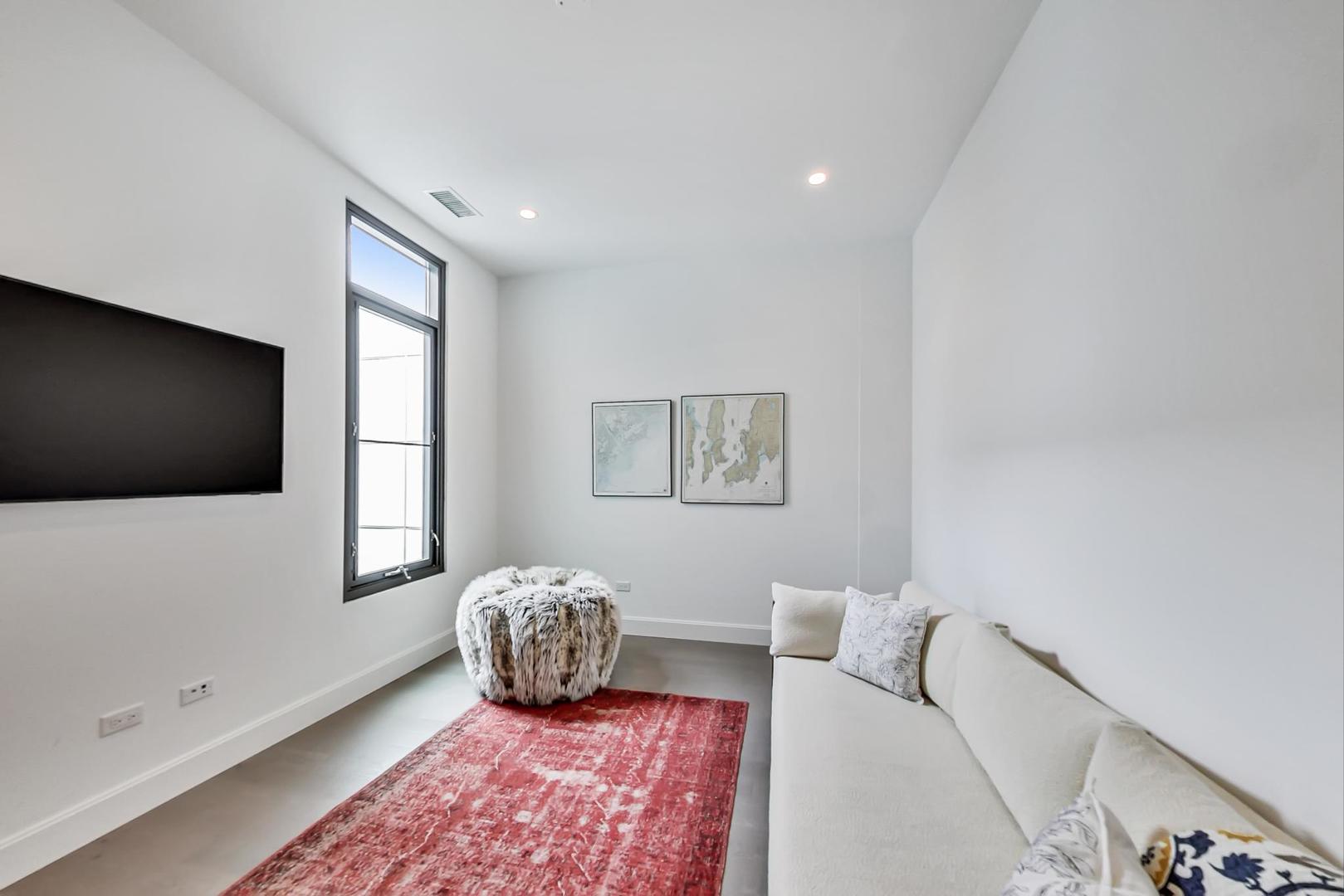 28 North Carpenter Street, Unit PHN Chicago, IL 60607 - Photo 10 of 14 a living room with furniture and a flat screen tv