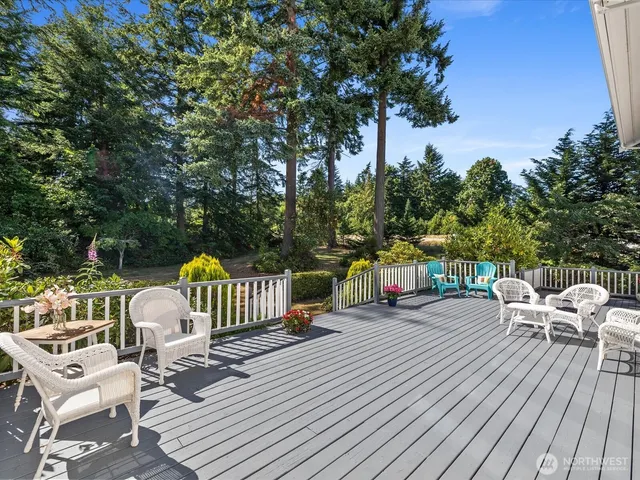 a view of a roof deck with table and chairs with wooden floor and fence