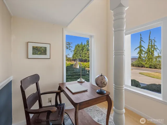 a view of a workspace with furniture and a window