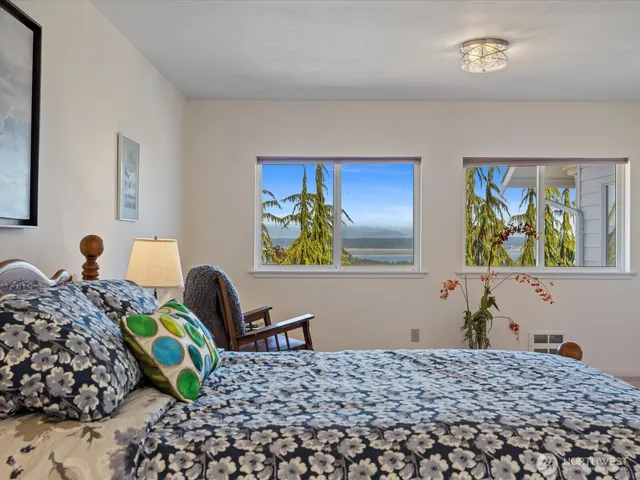 a bedroom with a bed and painting on the wall