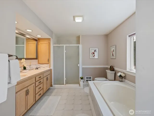 a bathroom with a tub sink and mirror