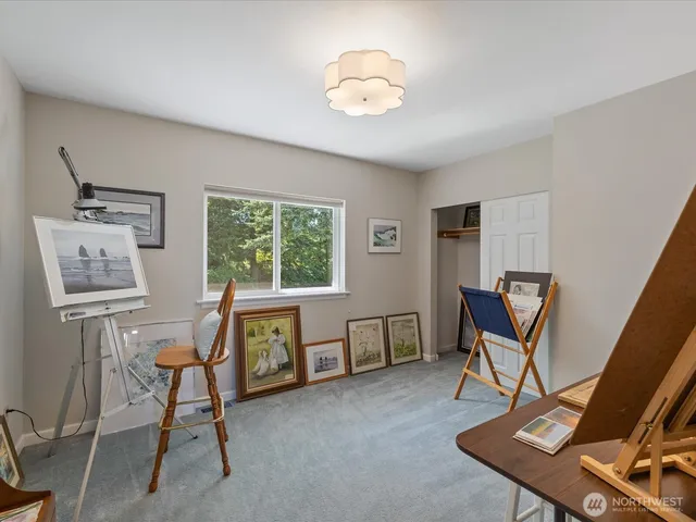 a view of a workspace with furniture and a window