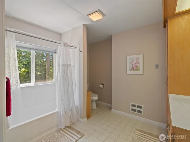 a bathroom with a granite countertop toilet and a shower