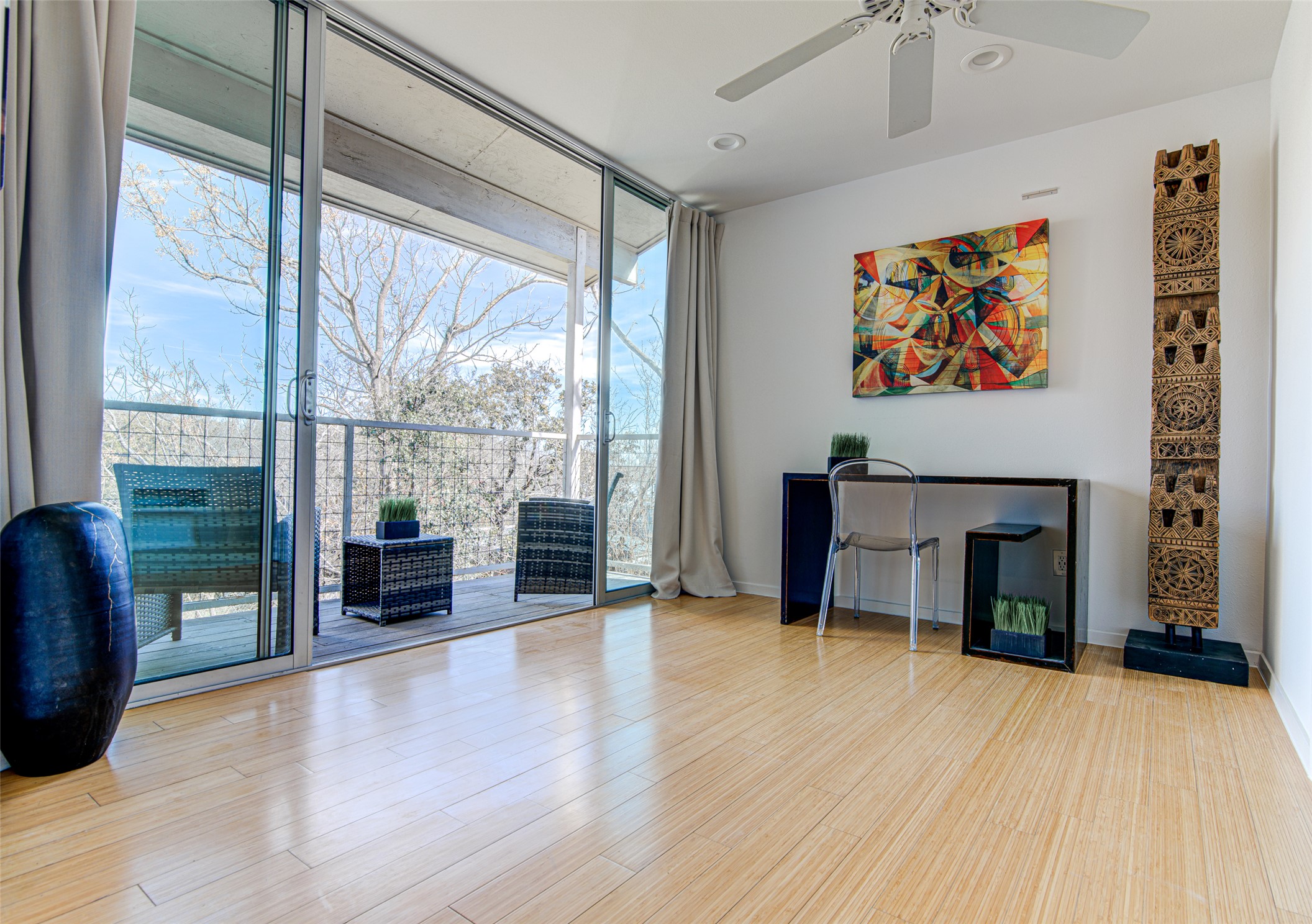 9707 Timber Ridge Pass Austin, TX 78733 - Photo 7 of 18 Gleaming hardwood floors and massive sliding glass doors leading to a private outdoor balcony.