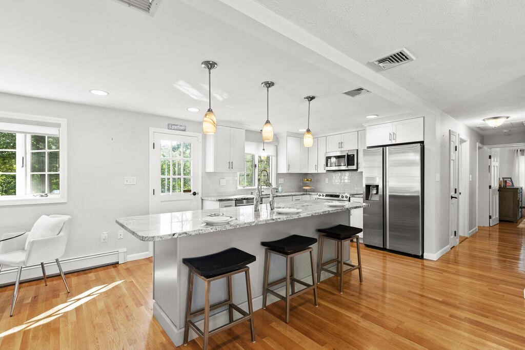 33 Doncaster Circle Lynnfield, MA 01940 - Photo 11 of 31 a kitchen with stainless steel appliances granite countertop a refrigerator a sink dishwasher a stove and white cabinets with wooden floor