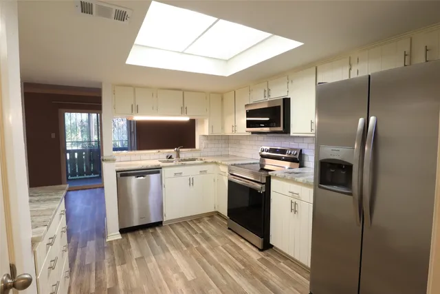 a kitchen with stainless steel appliances a refrigerator stove and microwave