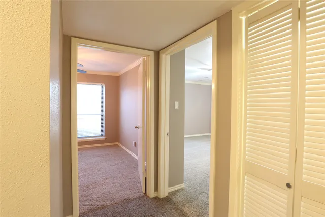 a view of an empty room with a chandelier fan