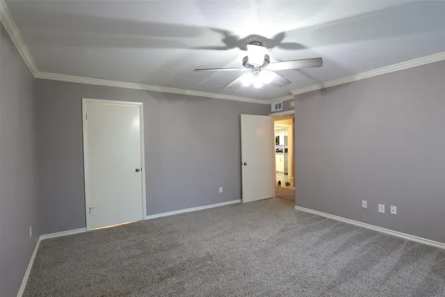 a view of a hallway with wooden floor and a bathroom