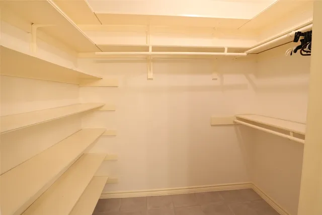 a view of walk in closet with empty racks