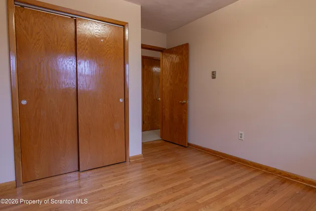 a view of a kitchen with a fridge and wooden floor